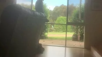 Jouer Kevin jouit devant la fenêtre pendant que le jardinier travaille à l'extérieur